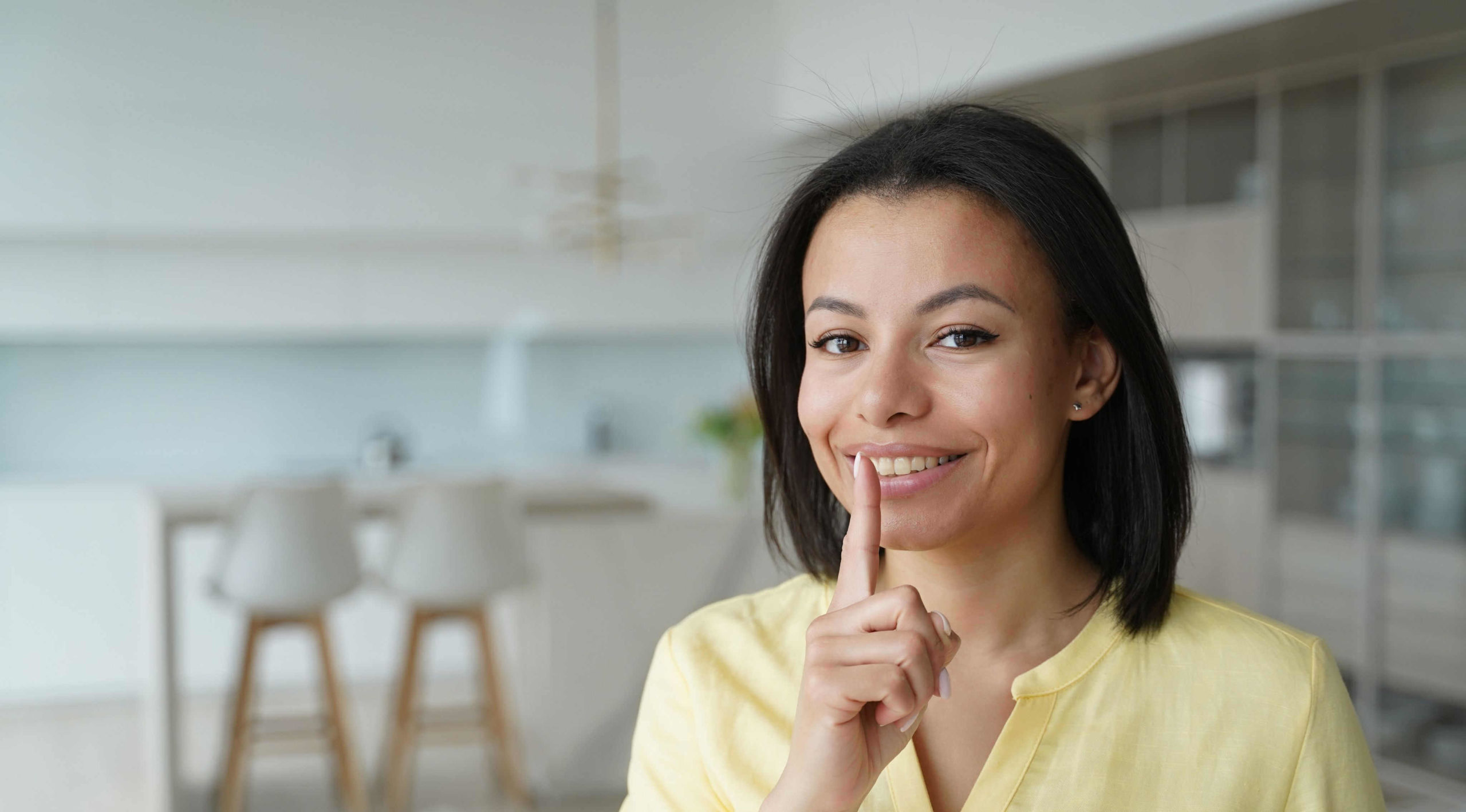 smiling-female-puts-finger-on-lips