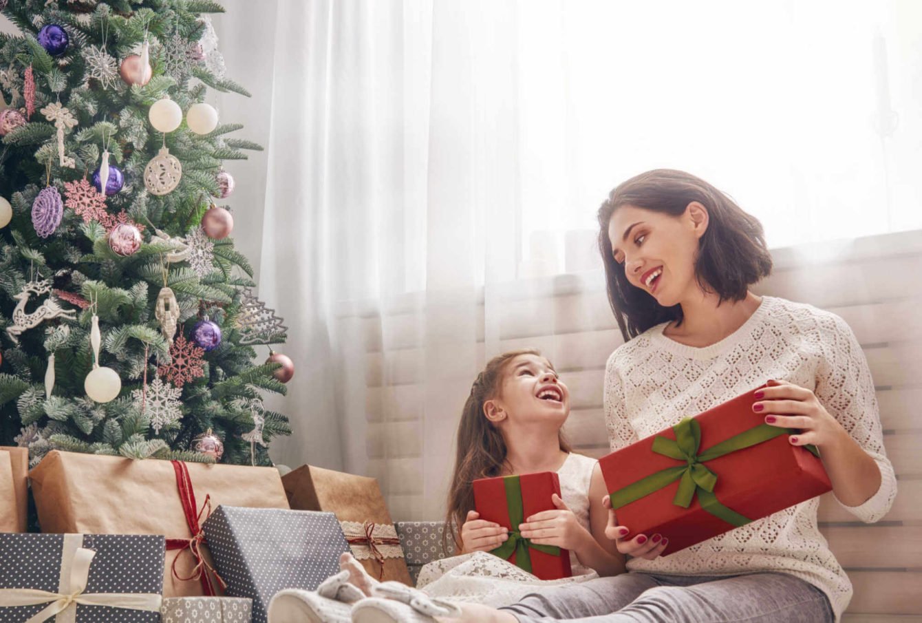 selling-property-during-christmas-cheerful-mom-exchanging-presents-daughter