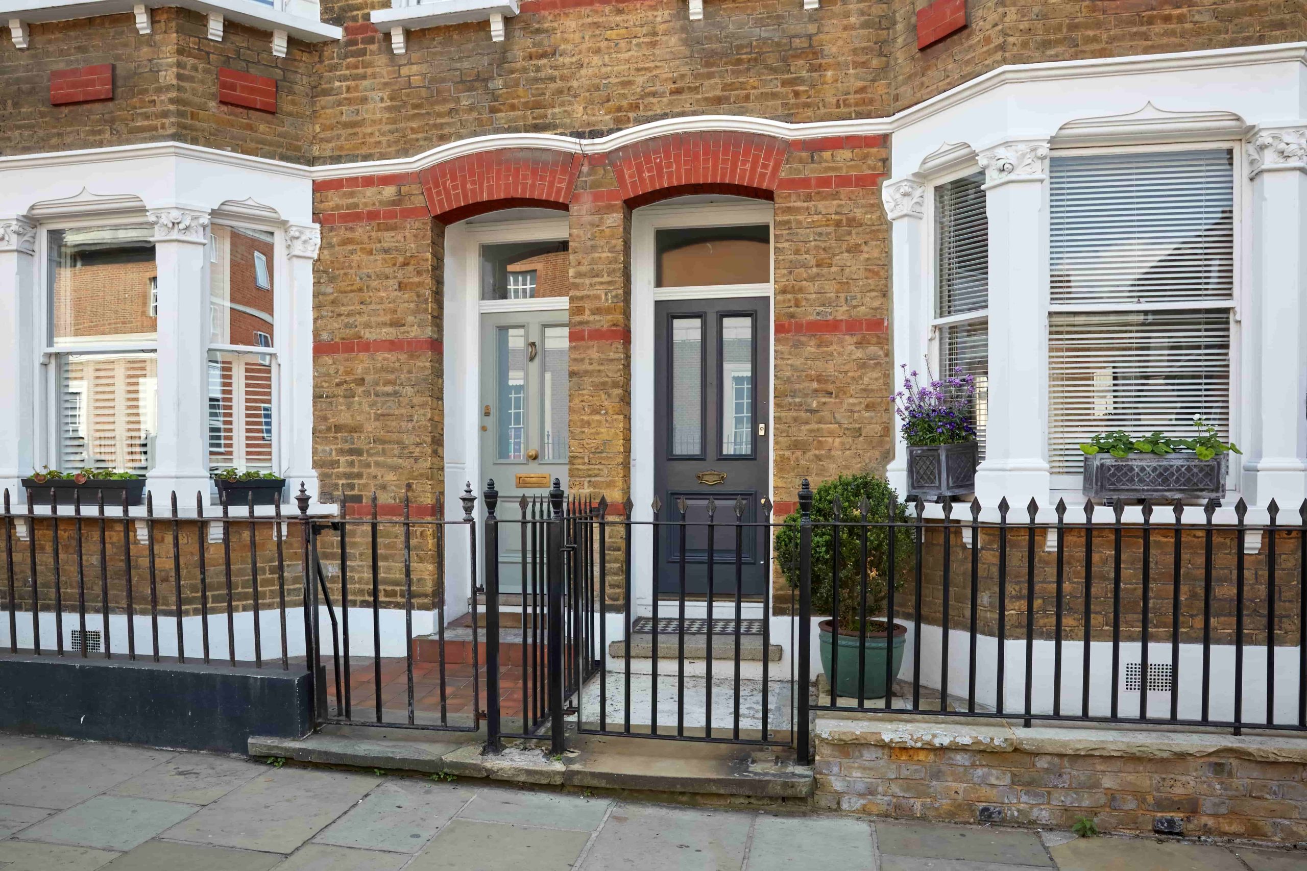 Apartment house with a white arcade and green plants, London, UK