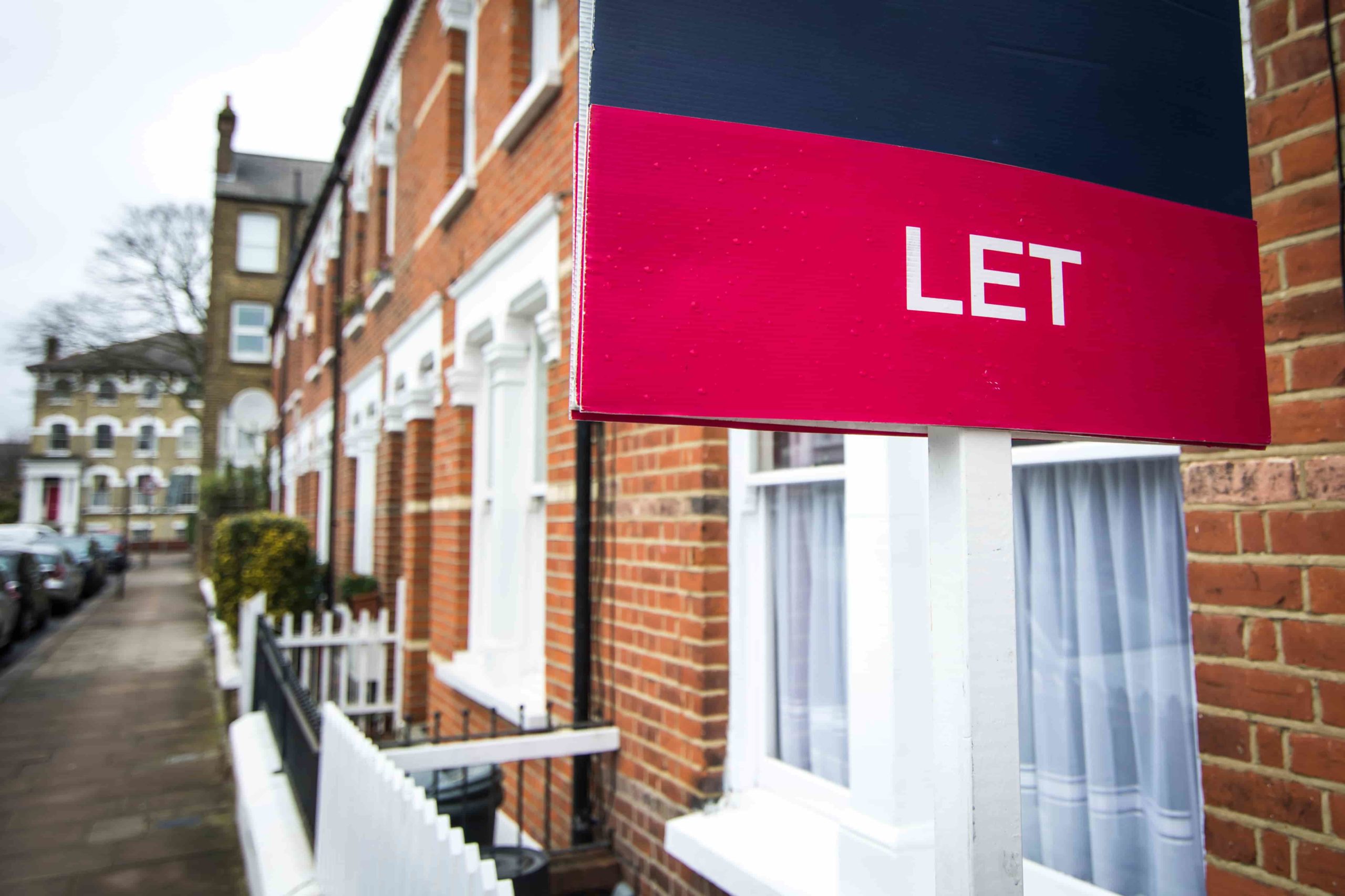 A street of red brick houses with 'Let' sign