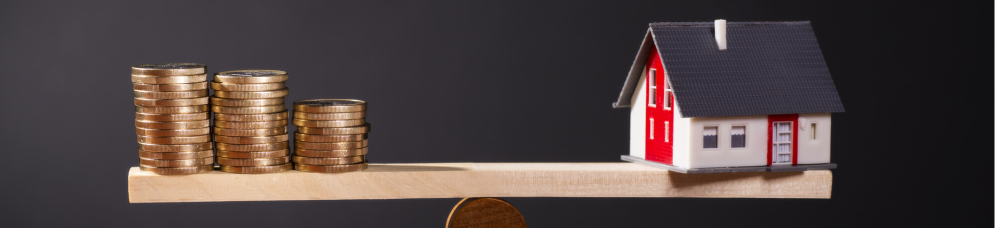 seesaw-house-and-stacks-of-coins