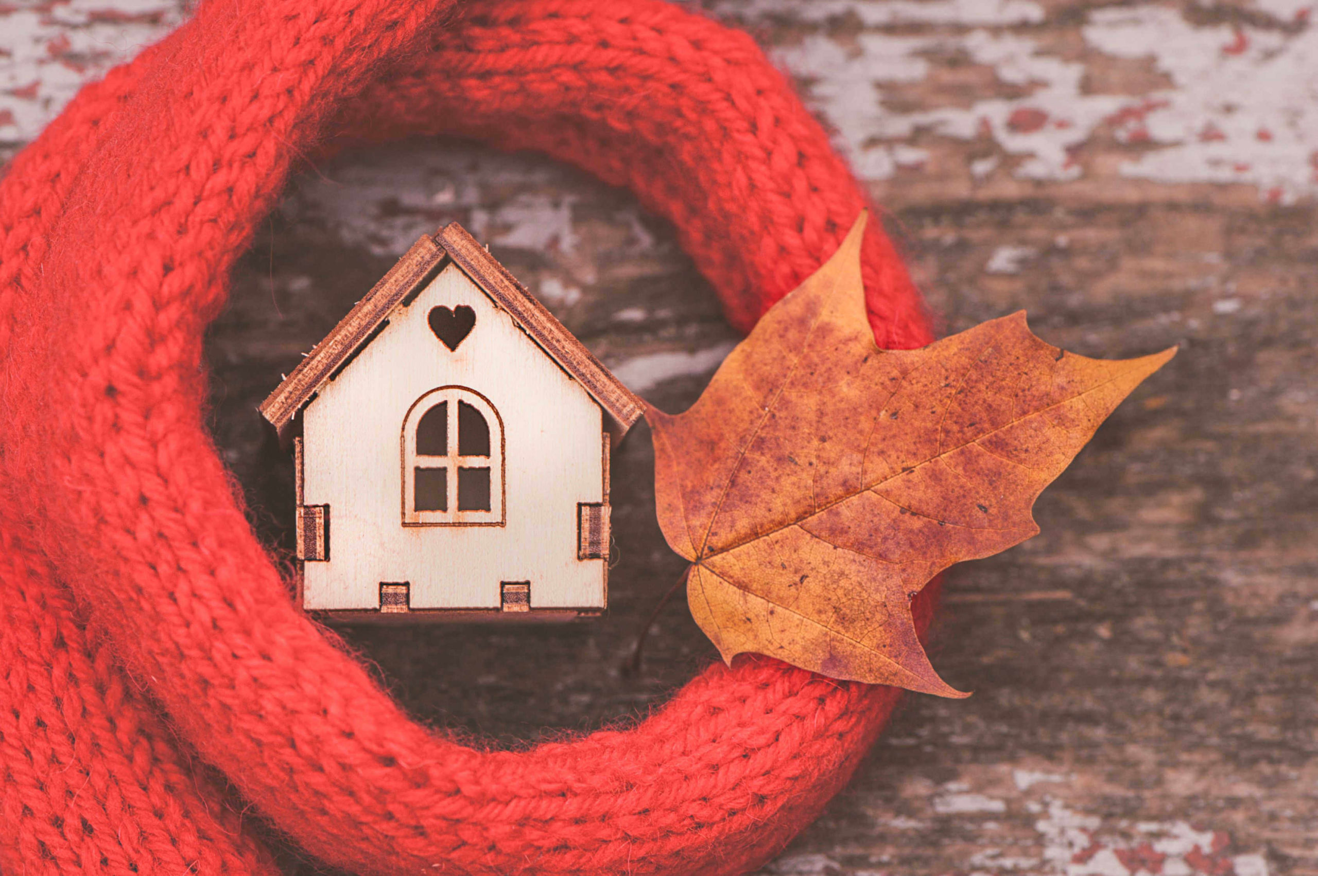 toy-house-wrapped-in-scarf-with-an-autumn-leaf