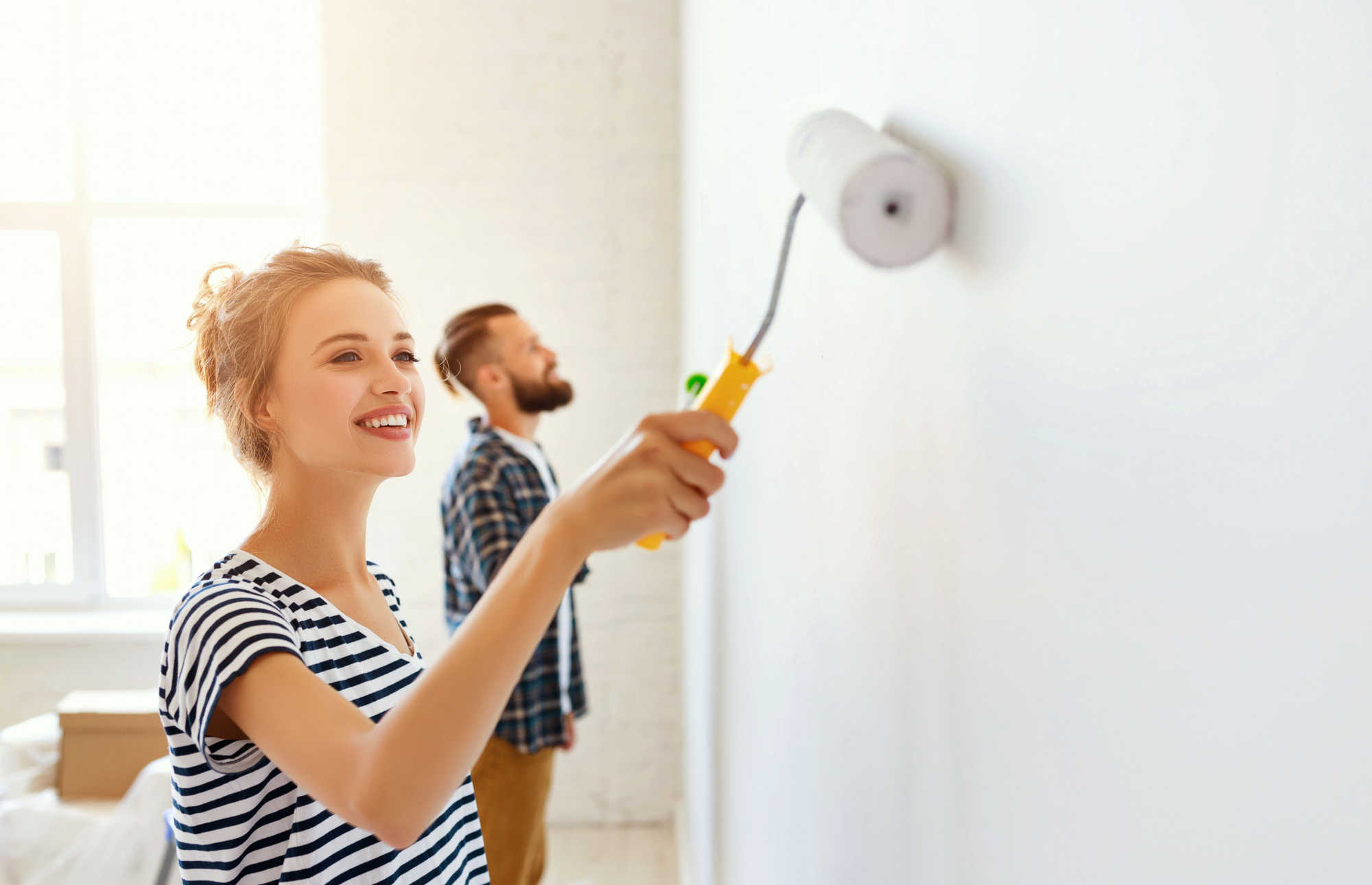 couple-repairing-painting-wall-what-not-to-fix-before-selling