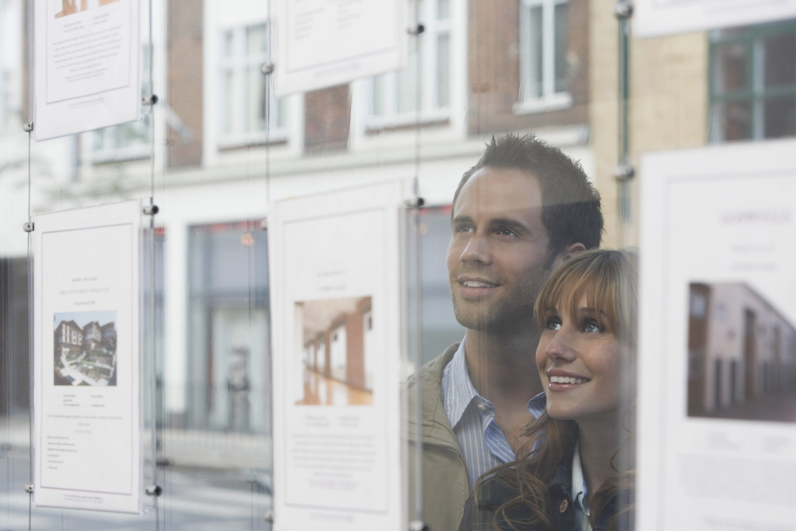 no-sale-no-fee-estate-agents-young-couple-looking-through-window