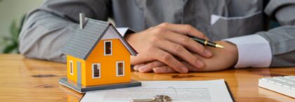 title-insurance-businessmen-holding-pens-signing-home-titles