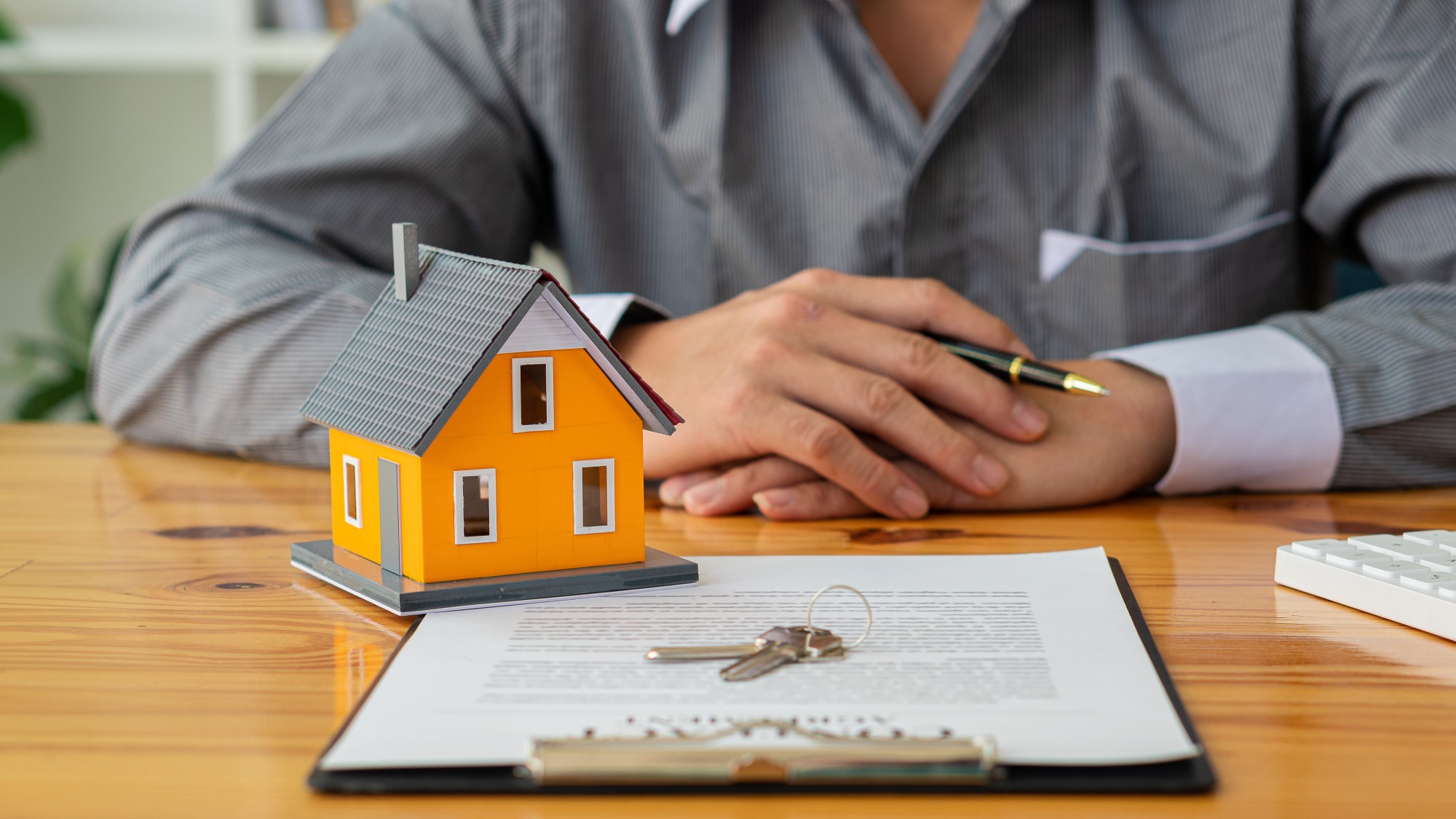 title-insurance-businessmen-holding-pens-signing-home-titles